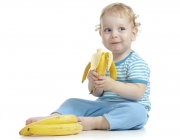 happy child eating healthy food fruits isolated on white