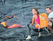 Hawaii lava tourist on hike. Tourists hiking near flowing lava from Kilauea volcano around Hawaii vo
