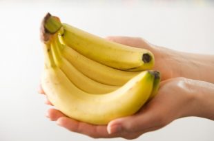 Cacho de Banana nas Mãos de uma Pessoa