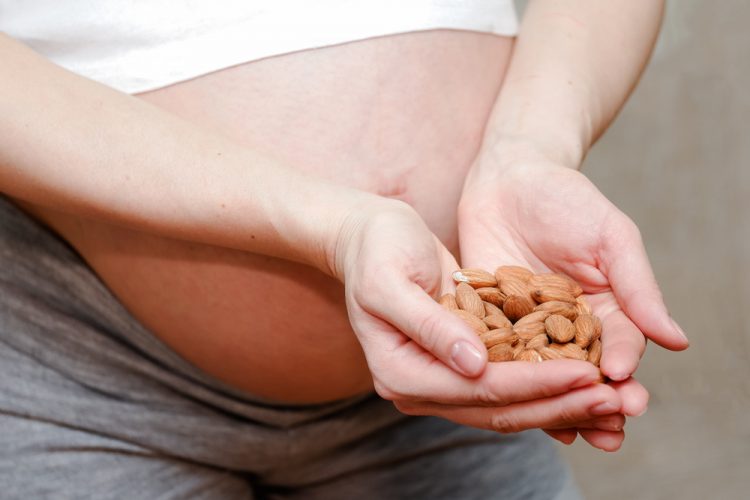 Amêndoas em uma colher de madeira — alimento fonte de magnésio e vitamina E